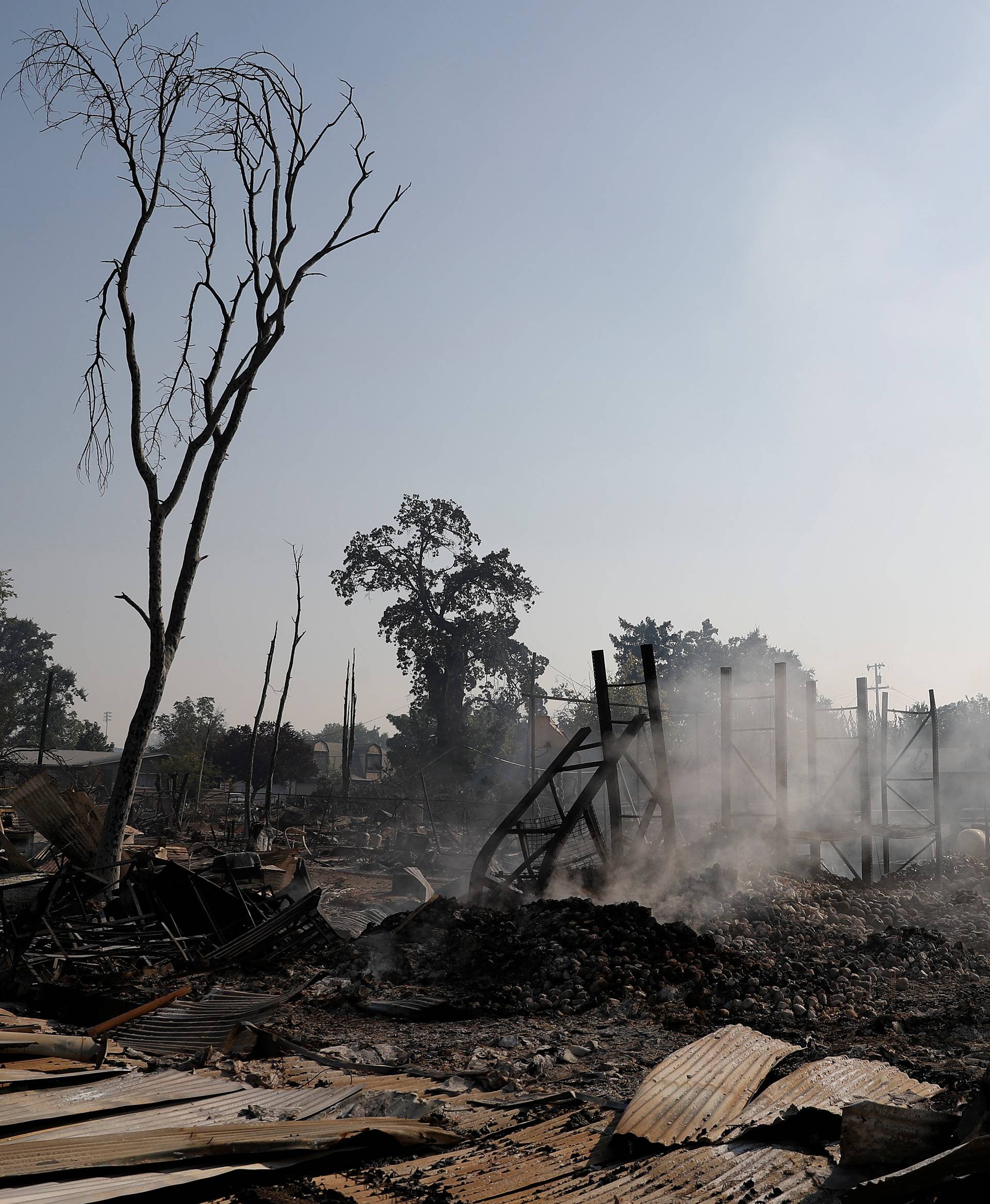 Smoke rises from properties destroyed by the Clayton Fire are seen near downtown Lower Lake in California