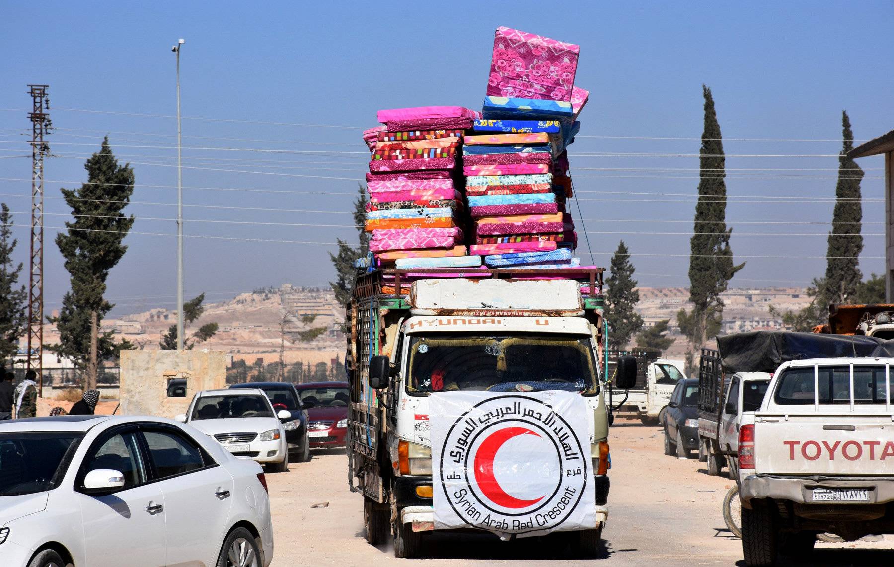 A Red Crescent vehicle carries mattresses in a government held-area in Aleppo, Syria