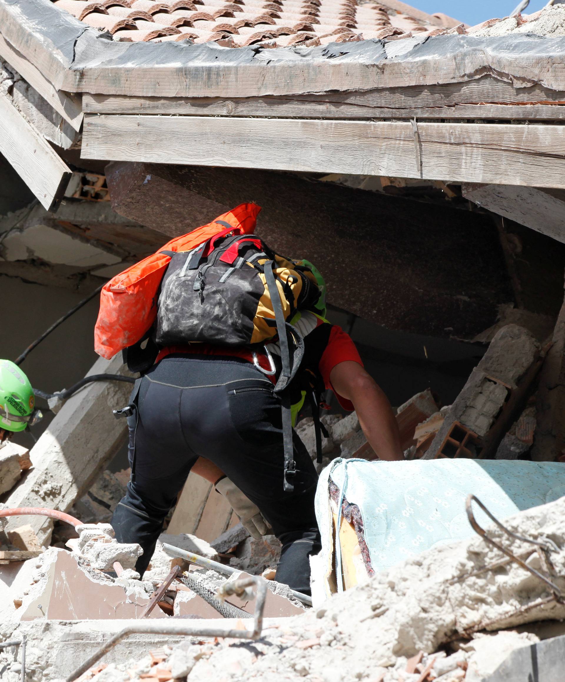 Rescuers work on a collapsed building following an earthquake in Amatrice