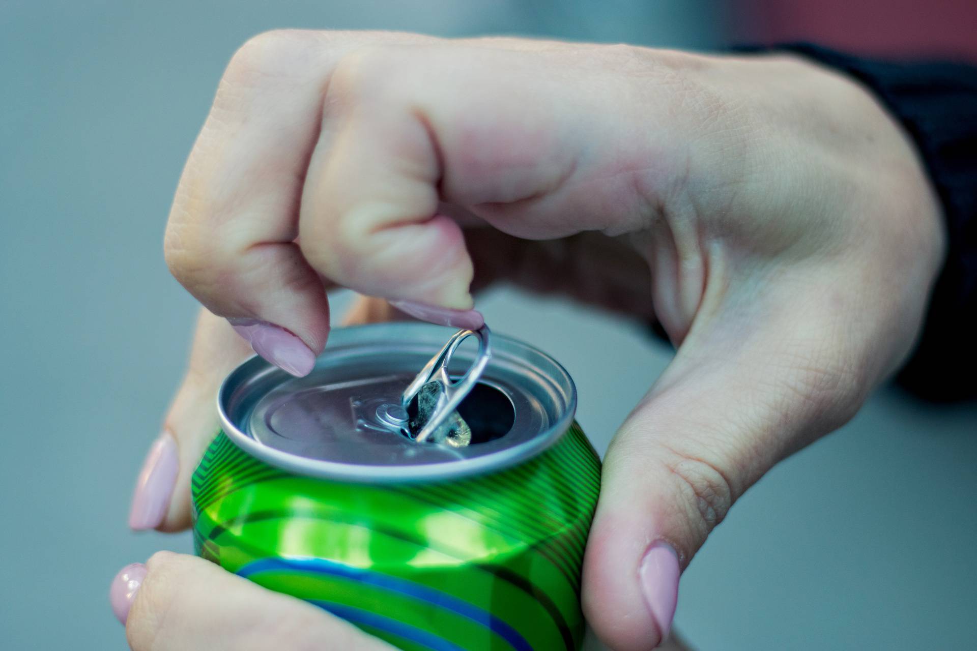 Close up of a hand opening a beverage