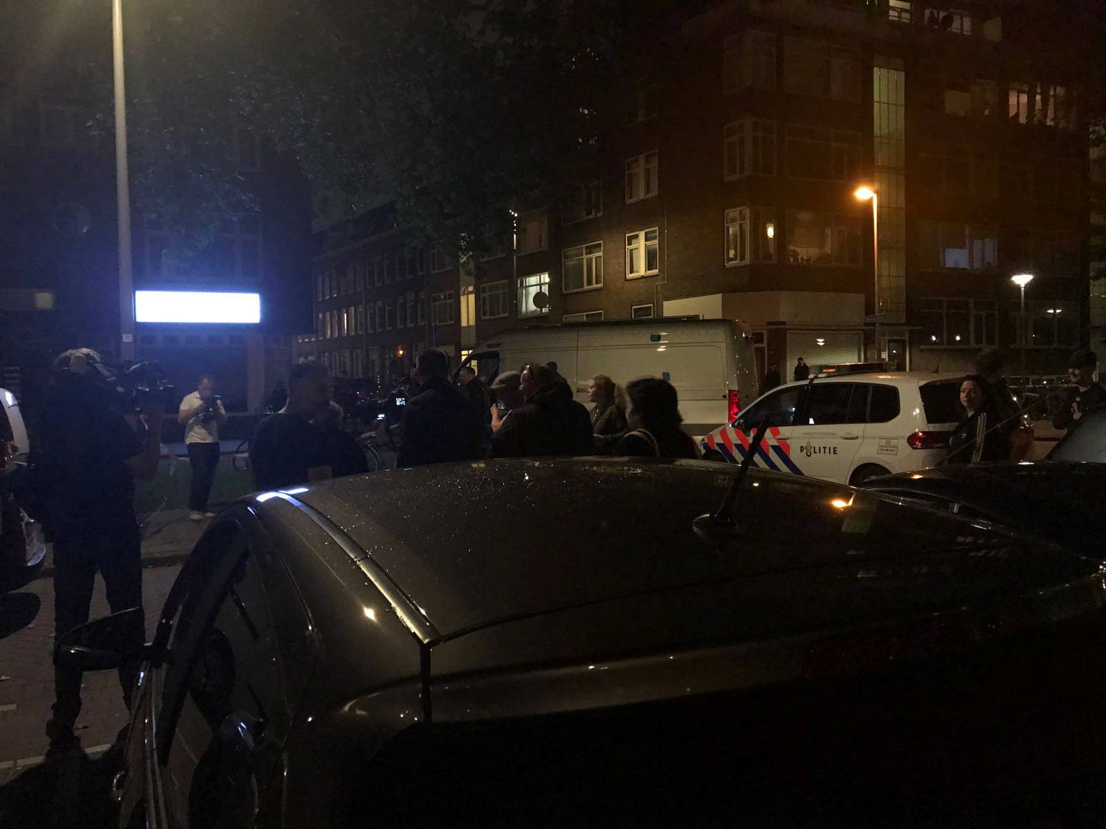 People gather at the scene where police are investigating a van with Spanish licence plates containing gas canisters which was found near a Rotterdam venue where a rock concert was cancelled
