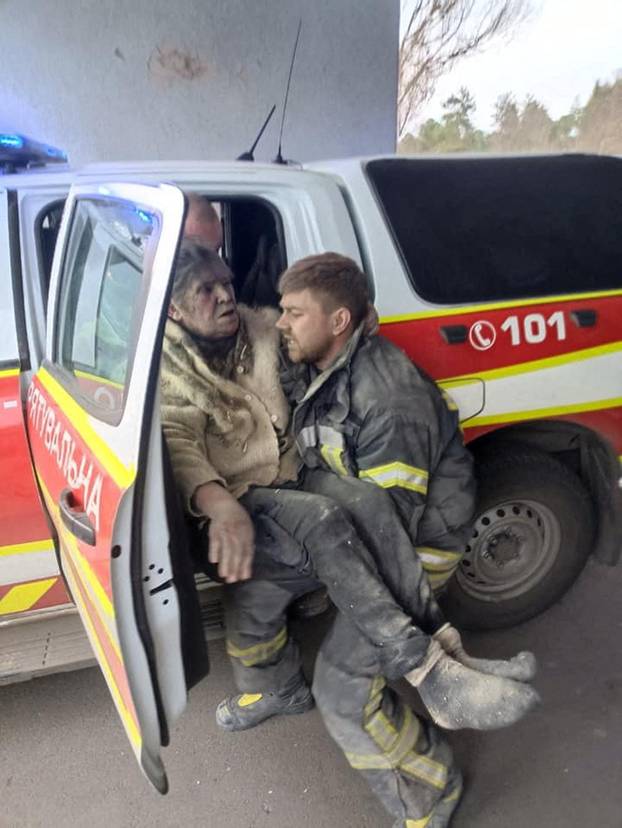 A rescuer carries a woman who was removed from debris after a military strike in Rubizhne