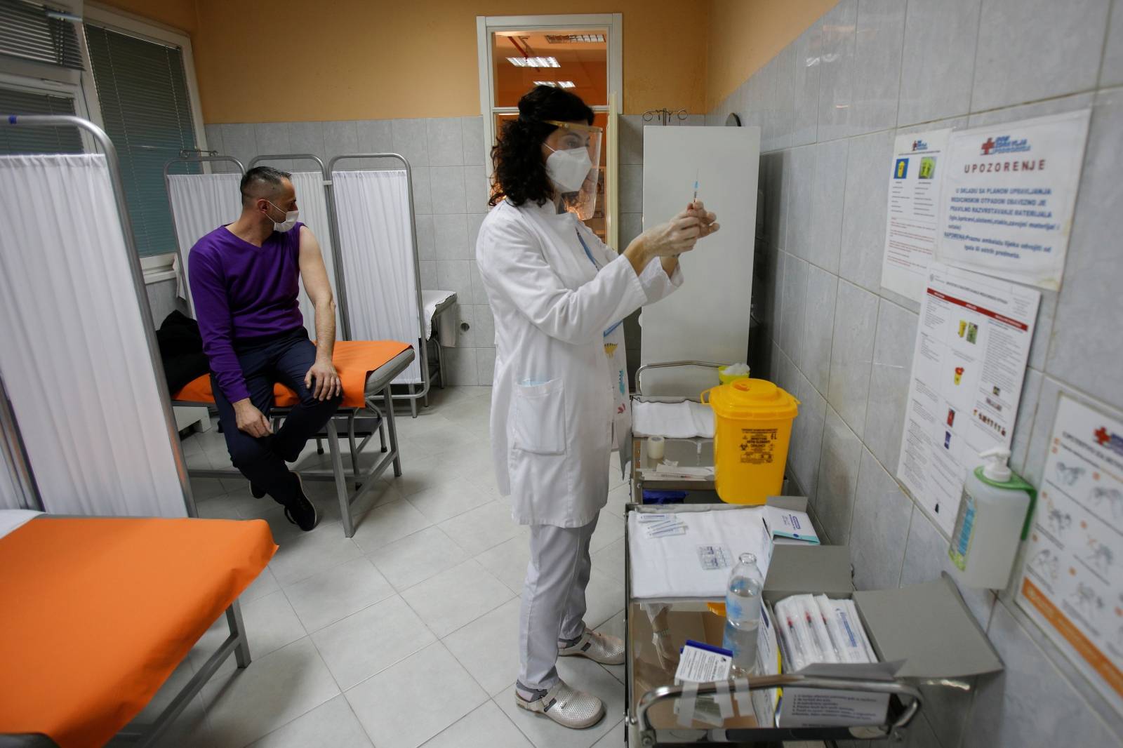 A healthcare worker prepares to administer a dose of the Sputnik V coronavirus disease (COVID-19) vaccine to her colleague in Podgorica