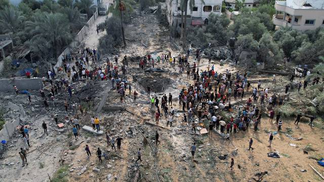 People work to remove the debris as they search for bodies, in the central Gaza Strip