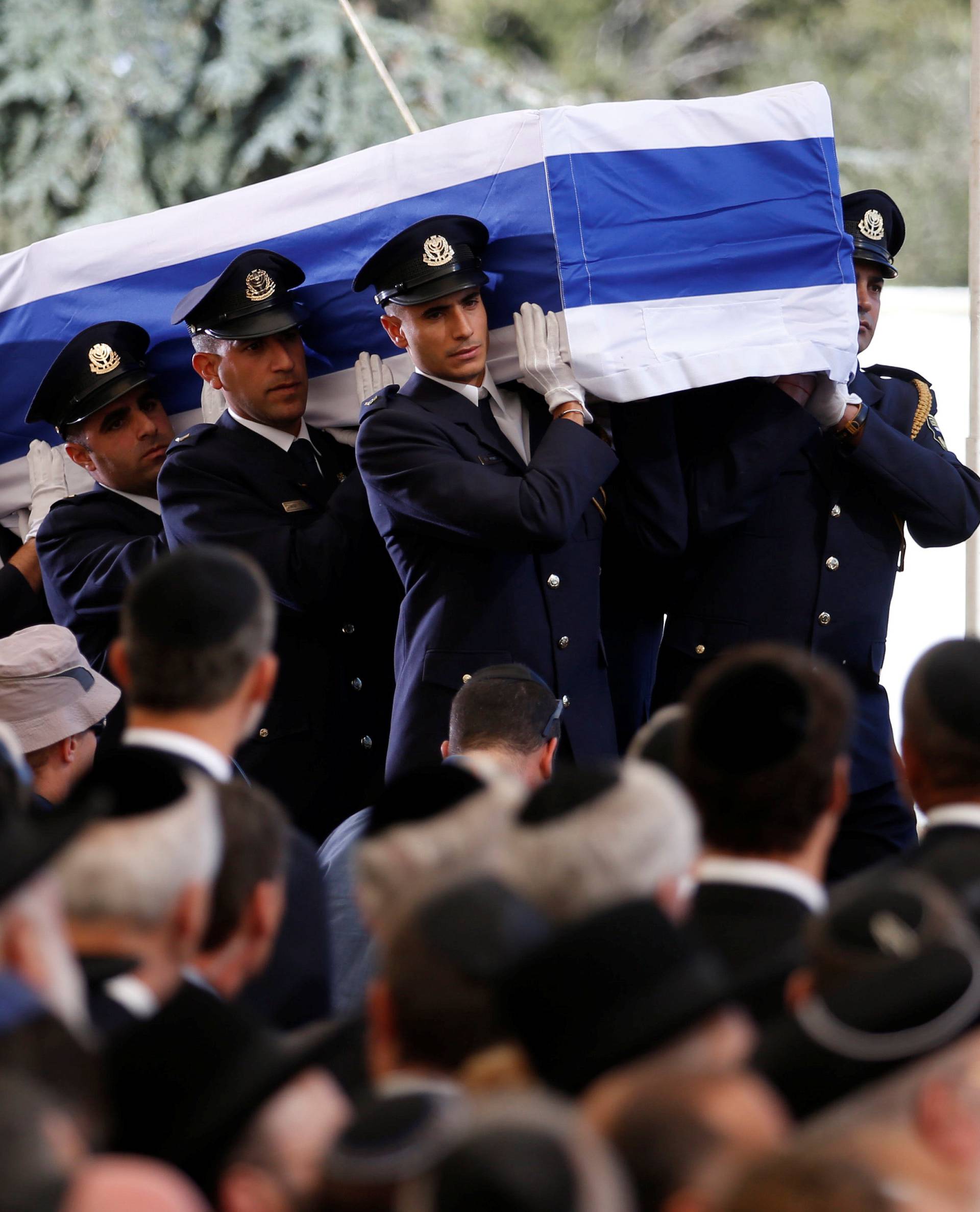 The flag-draped coffin of former Israeli President Shimon Peres is carried by an honour guard at the start of his funeral ceremony at Mount Herzl cemetery in Jerusalem