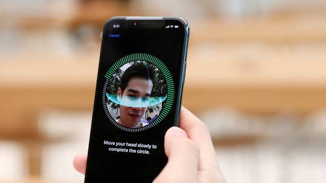 A customer sets up his iPhone X Face ID during its launch at the Apple store in Singapore