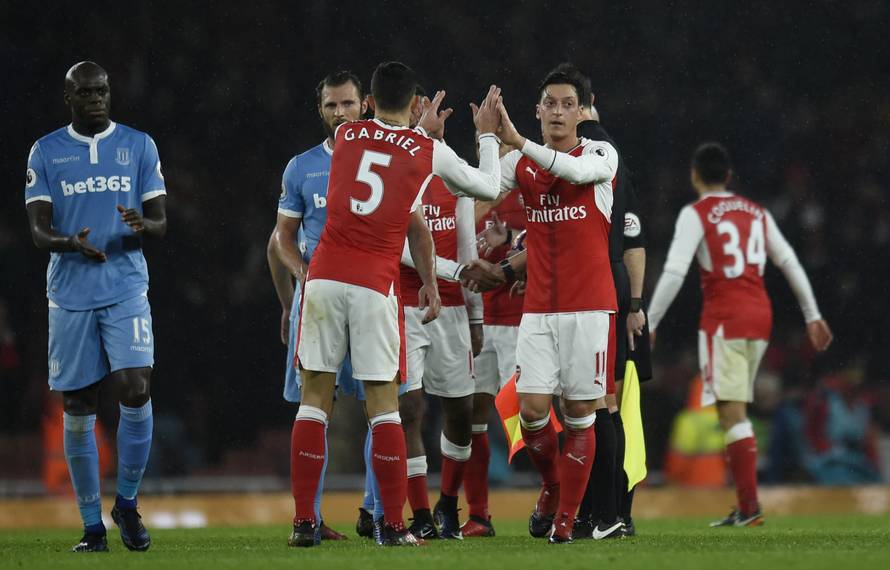 Arsenal's Gabriel Paulista and Mesut Ozil celebrate after the game
