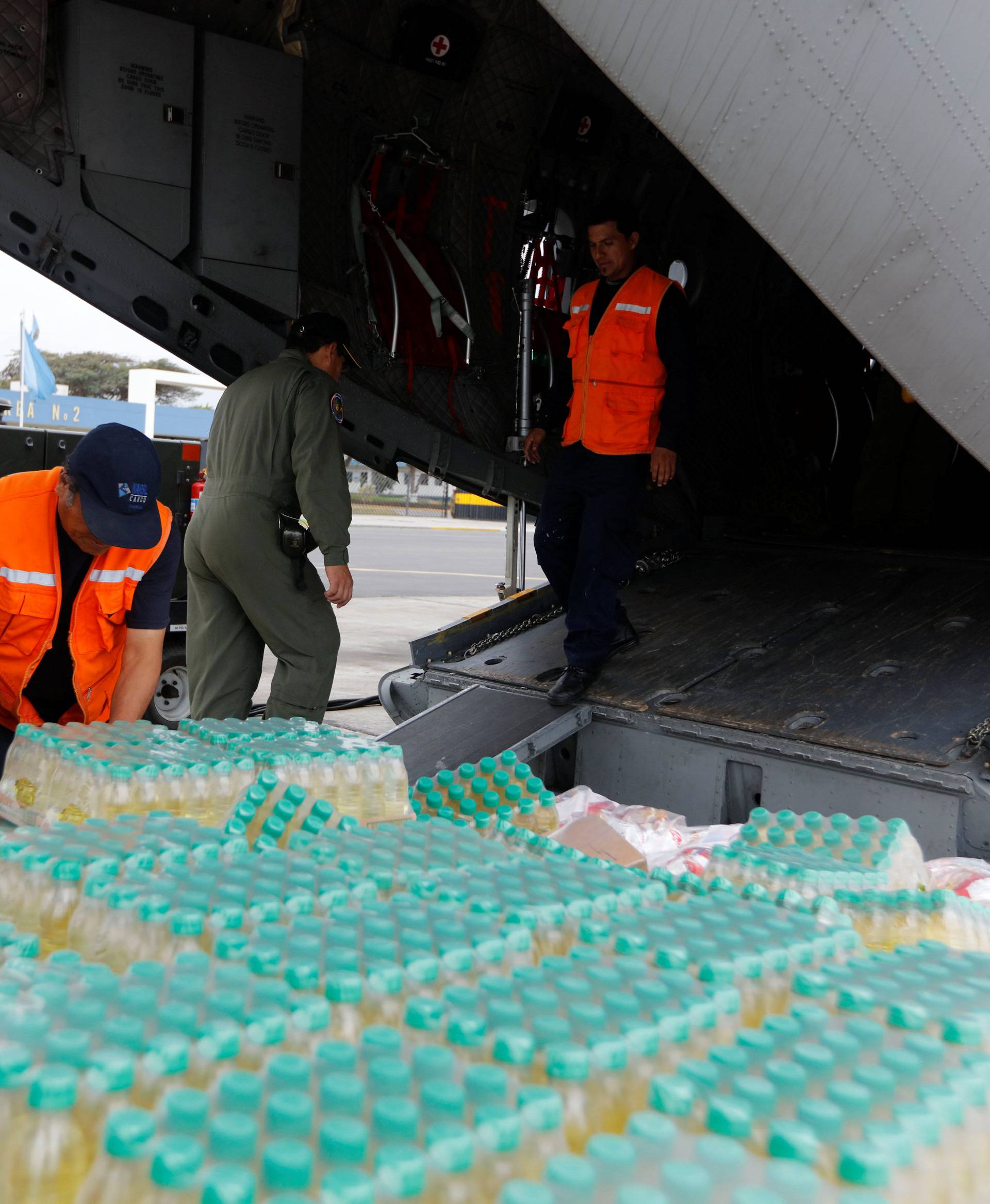 Members of Peru's National Institute of Civil Defense and Peru's Air Force load a cargo plane with aid to be delivered to the Caylloma province of the Andean region Arequipa after a 5.3 magnitude shallow earthquake rocked the region, in Lima