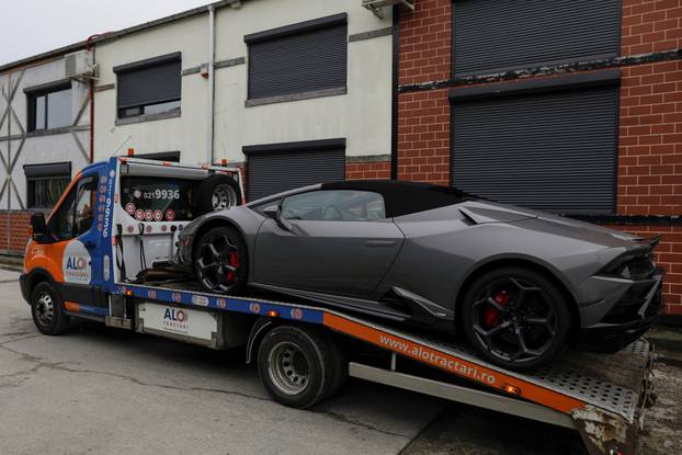 Romanian officials transport the cars seized from the Tate compund to a storage location