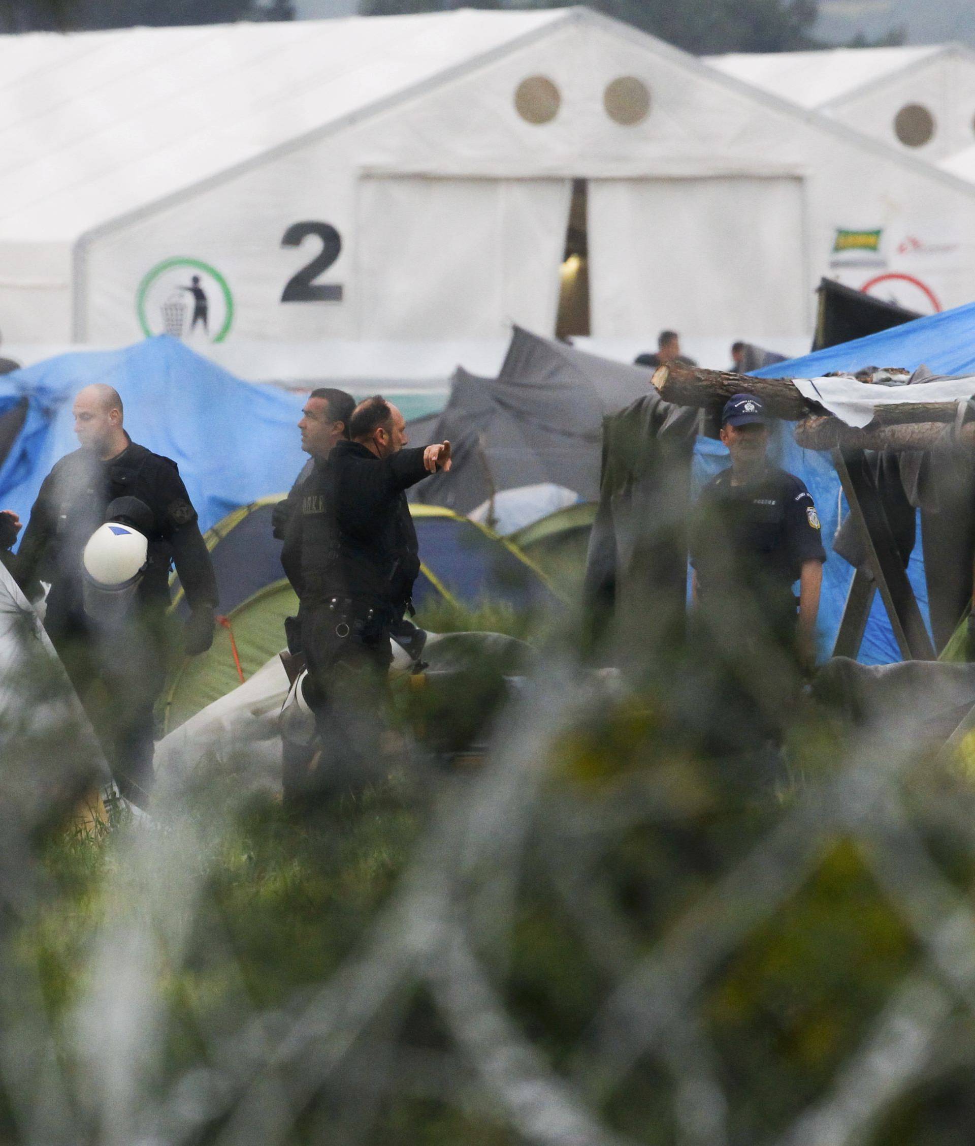 Greek policemen operate at a makeshift camp for migrants and refugees at the Greek-Macedonian border near the village of Idomeni