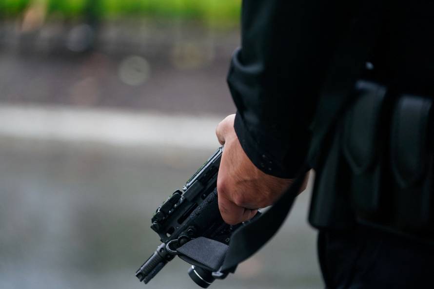 A U.S. Secret Service agent stands guard holding his weapon after alleged gunshots were heard nearby, at the White House in Washington