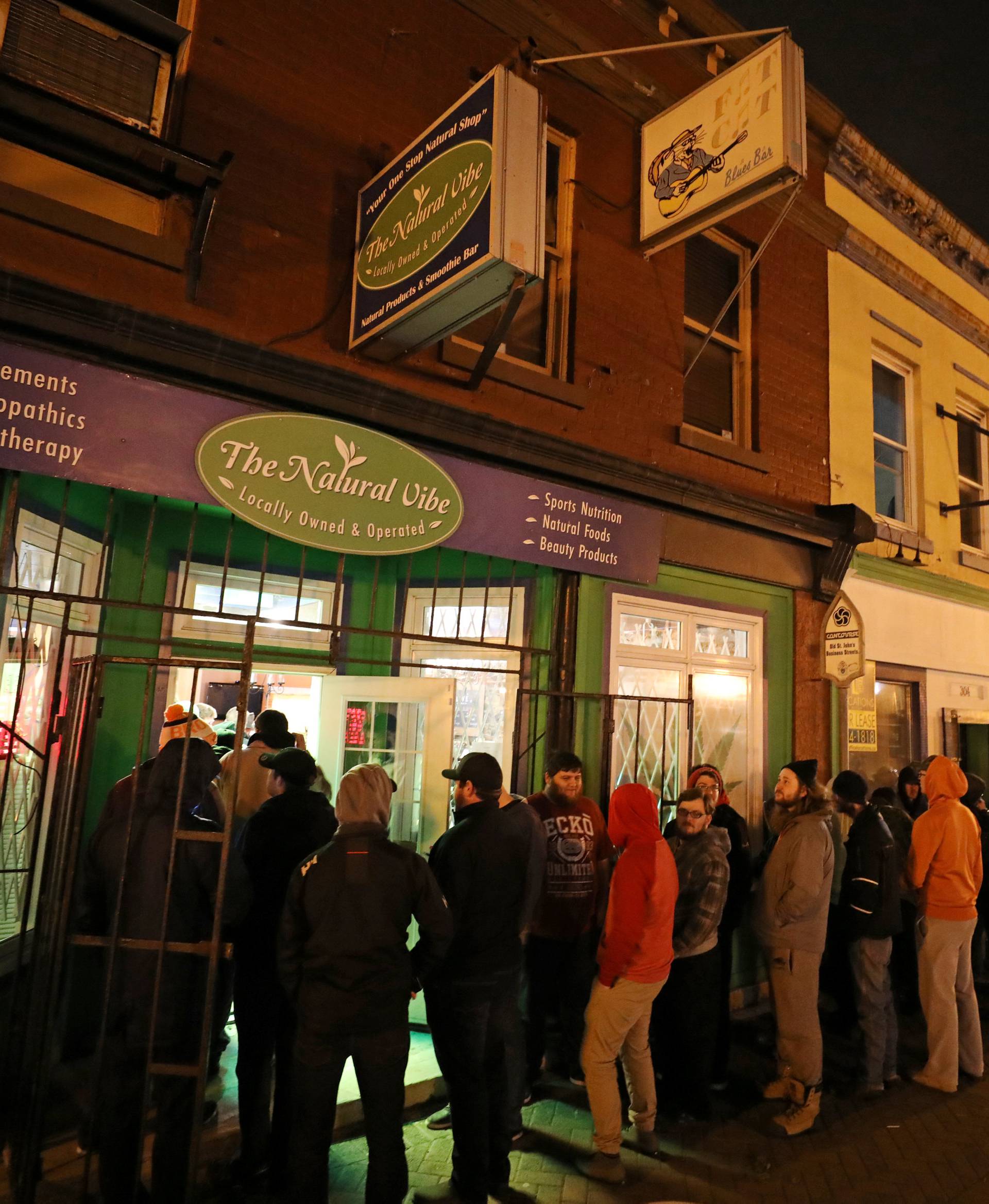 Customers line up outside the Natural Vibe store after legal recreational marijuana went on sale in St John's