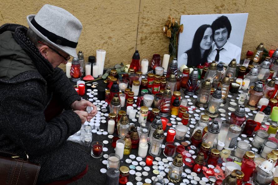A man lights a candle for a tribute to murdered Slovak investigative reporter Jan Kuciak at Slovak National Uprising Square in Bratislava