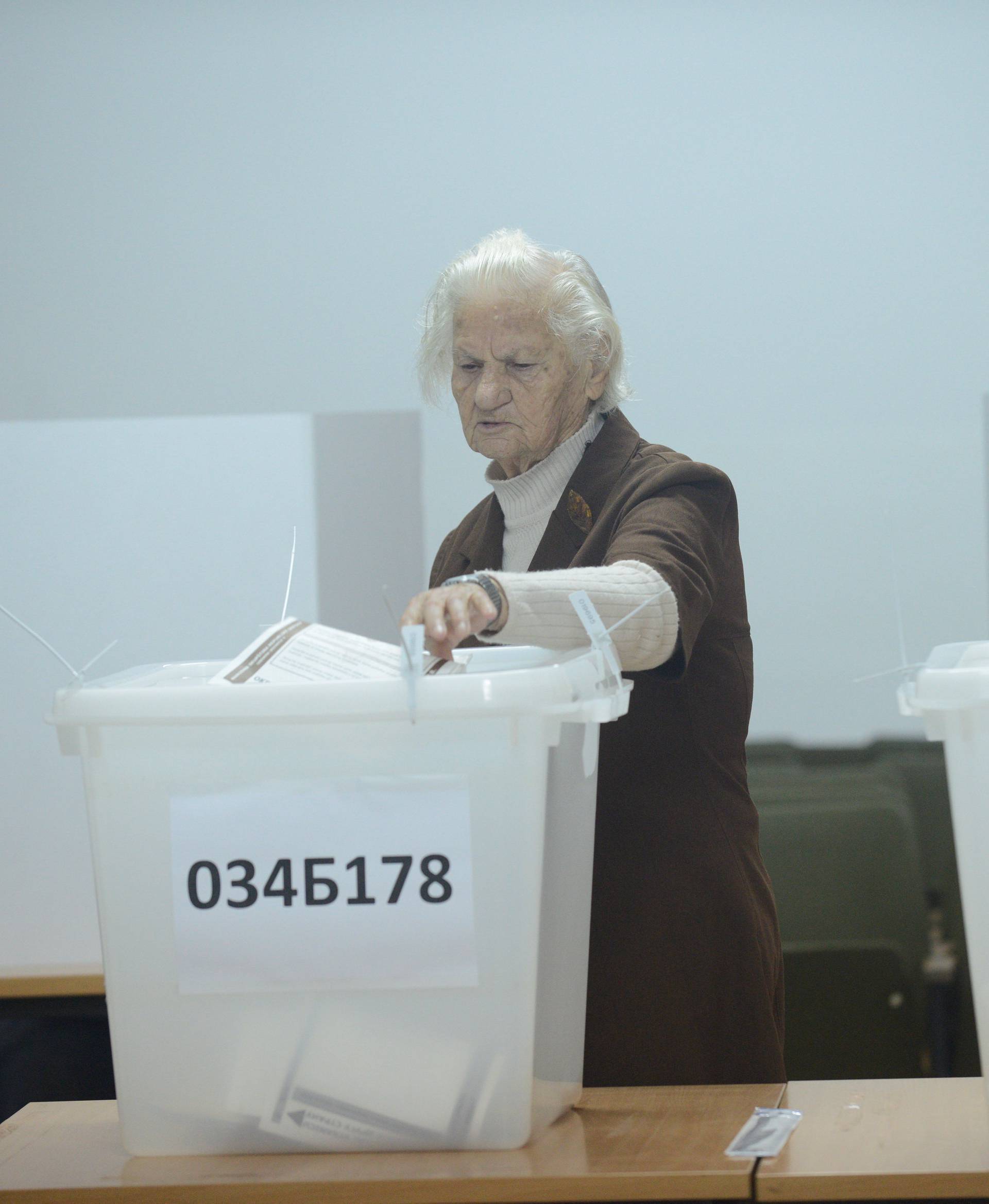 A woman casts her ballot during presidential and parliamentary elections at a polling centre in a school in Banja Luka