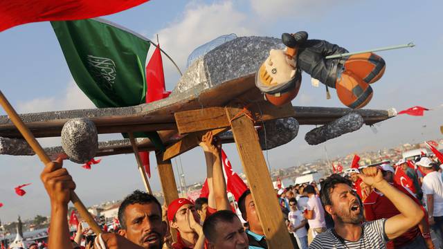 People hold a plane model with attached toy depicting oposition cleric in exile Gulen during the Democracy and Martyrs Rally in Istanbul