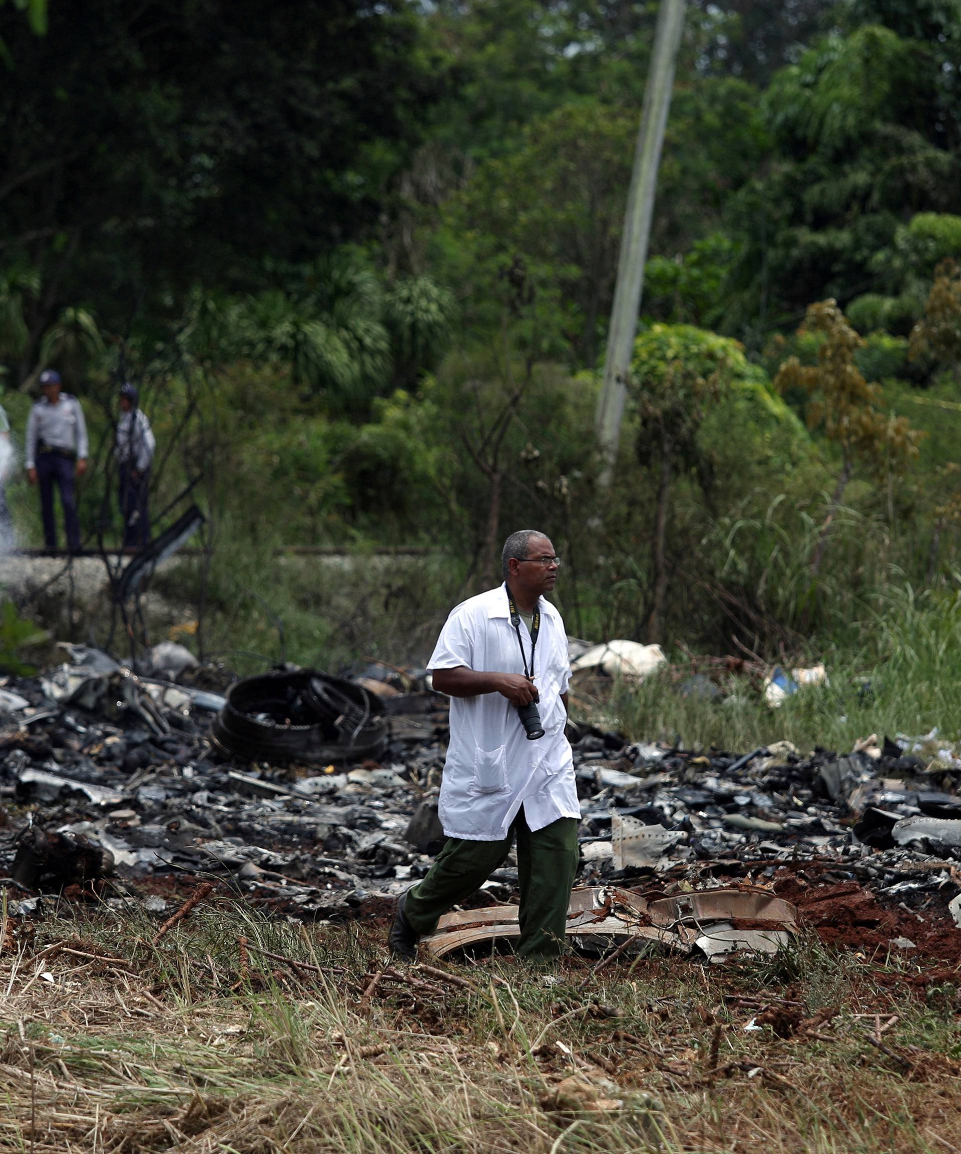 Rescue team members work in the wreckage of a Boeing 737 plane that crashed in the agricultural area of Boyeros