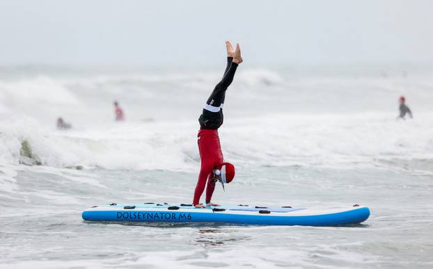 Surfing Santas take to the waves at the annual Christmas Eve event in Cocoa Beach