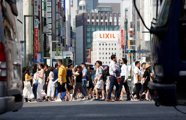 Passersby walk on a street during a heatwave in Tokyo