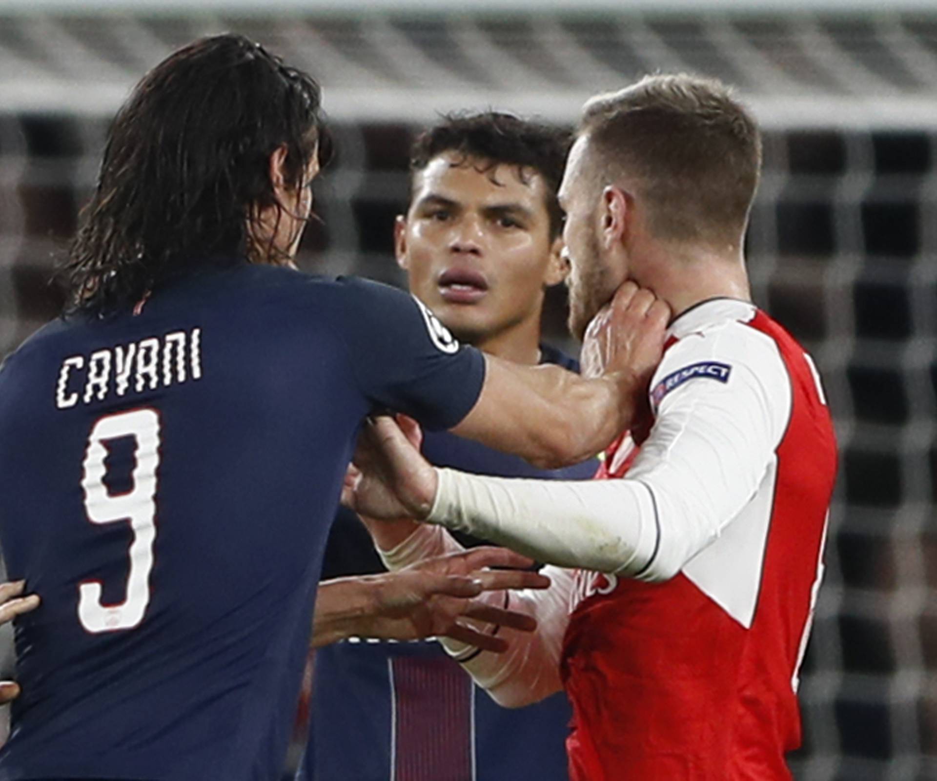 Paris Saint-Germain's Edinson Cavani clashes with Arsenal's Aaron Ramsey as Thiago Silva looks on