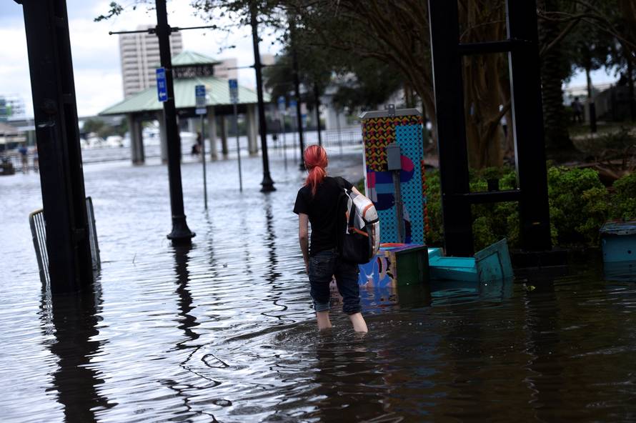 A woman walks barefoot through floodwaters after Hurricane Irma