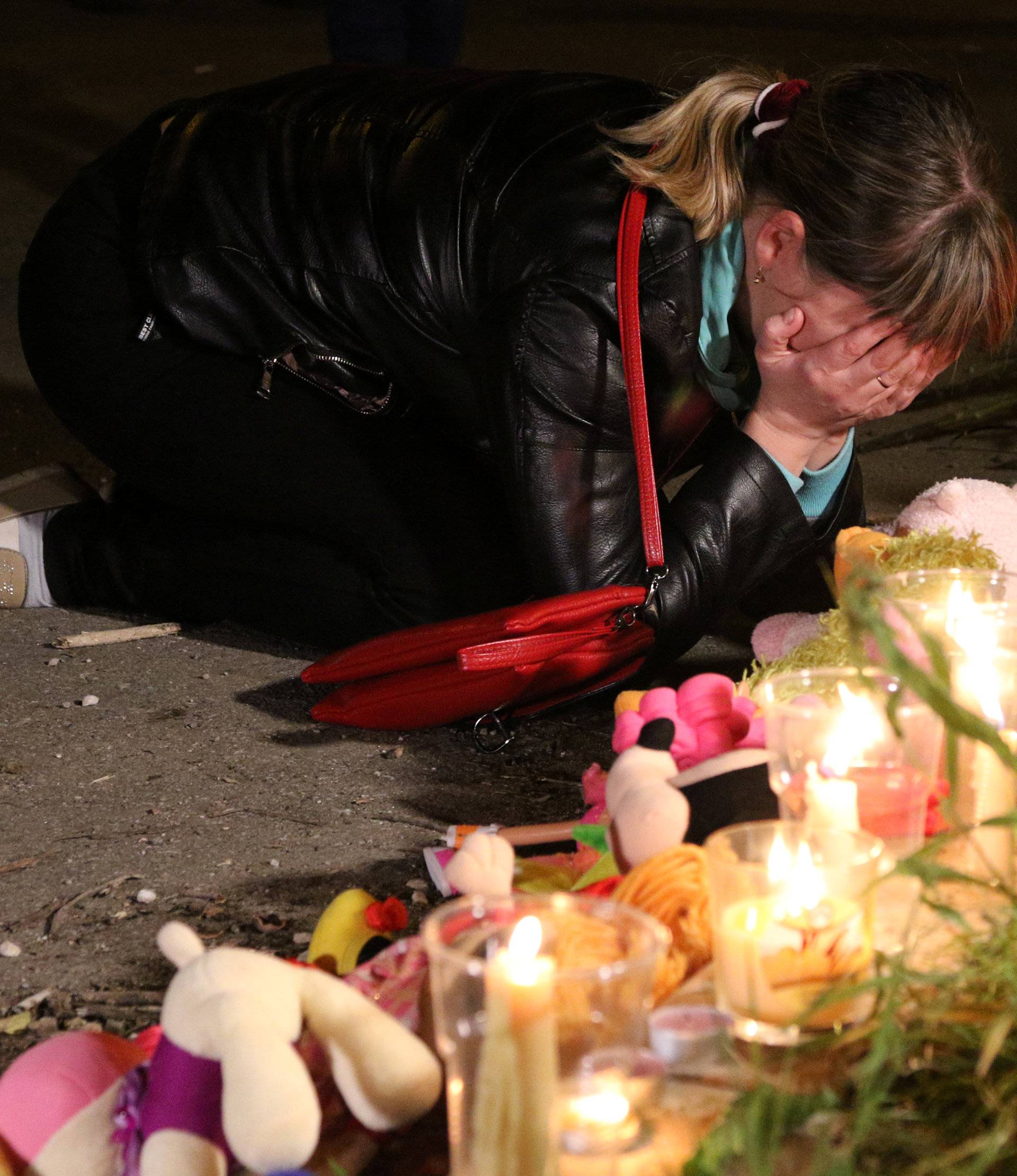 A mourner reacts at a makeshift memorial near the scene of a fatal attack on a college in Kerch