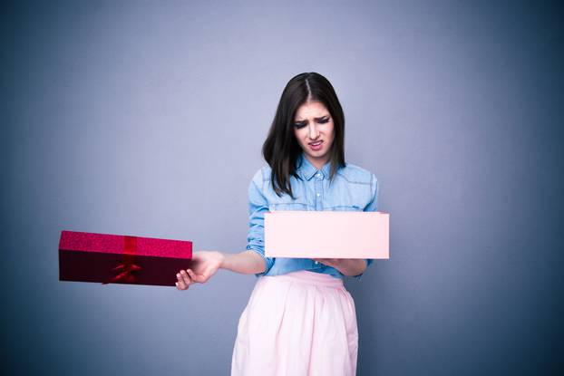 Dissatisfied woman opening gift