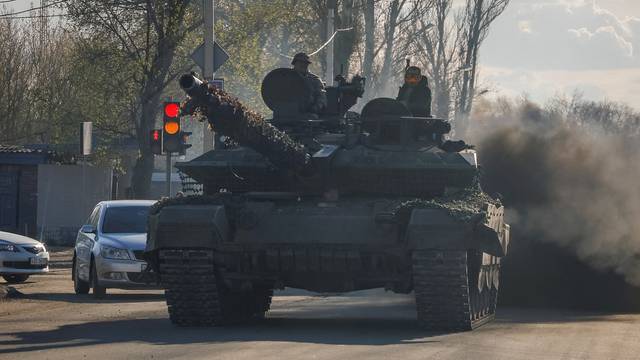 Russian army servicemed drive a tank on a street in Donetsk