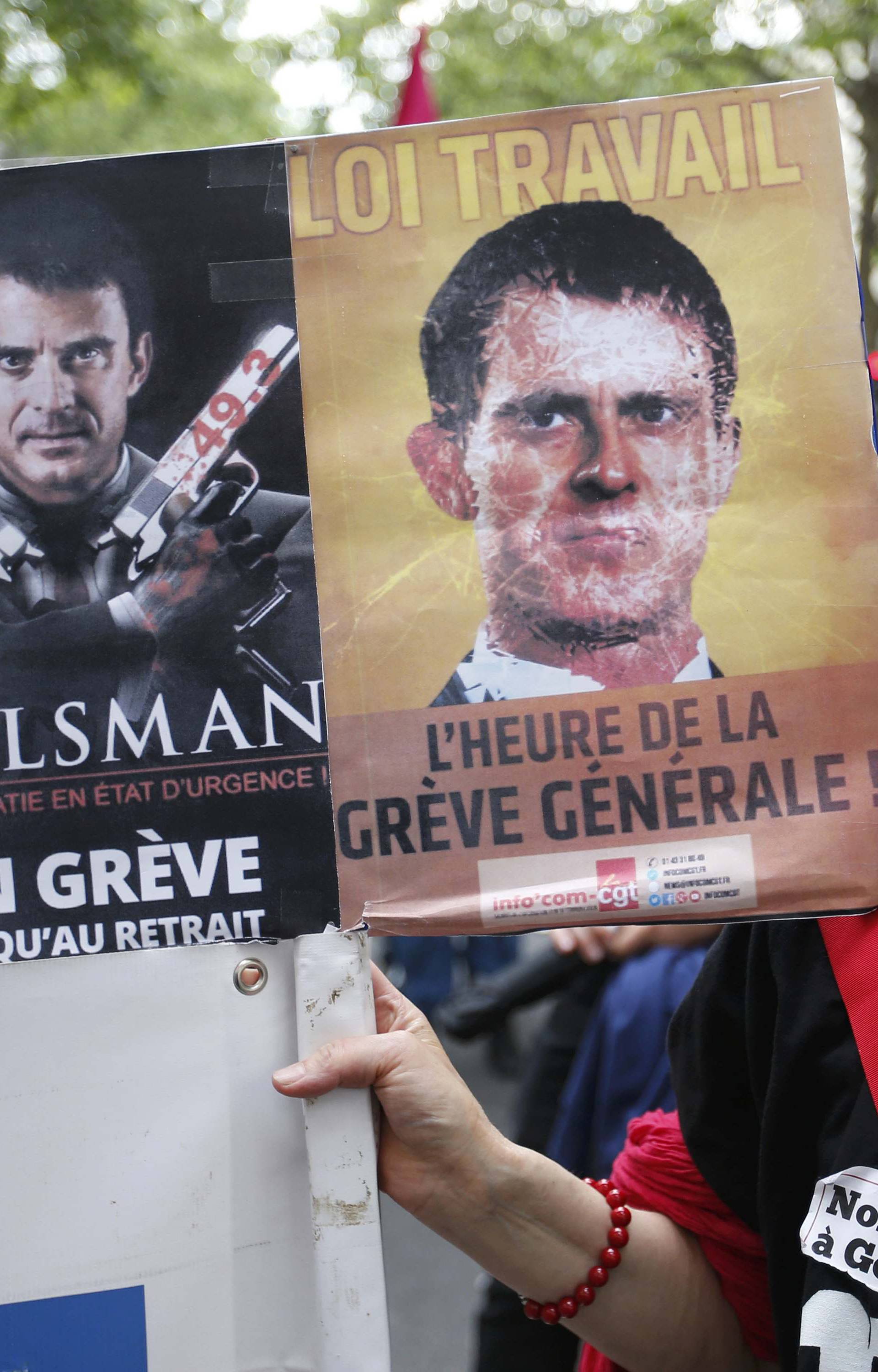 A French labour union member marches with a message critical of French prime minister during a demonstration in protest of the government's proposed labor law reforms in Paris
