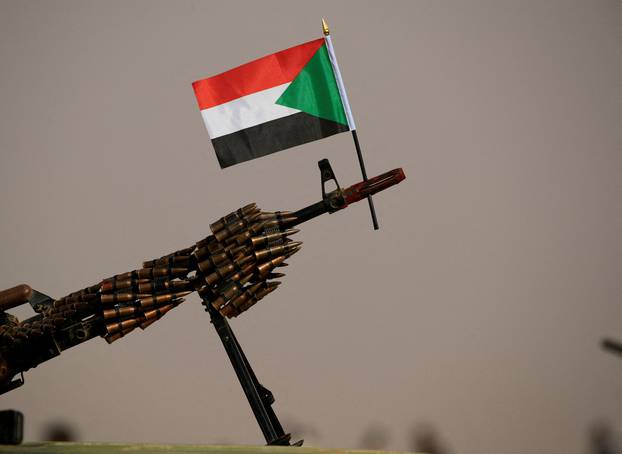 FILE PHOTO: A Sudanese national flag is attached to a machine gun of Paramilitary Rapid Support Forces (RSF) soldiers as they wait for the arrival of Lieutenant General Mohamed Hamdan Dagalo before a meeting