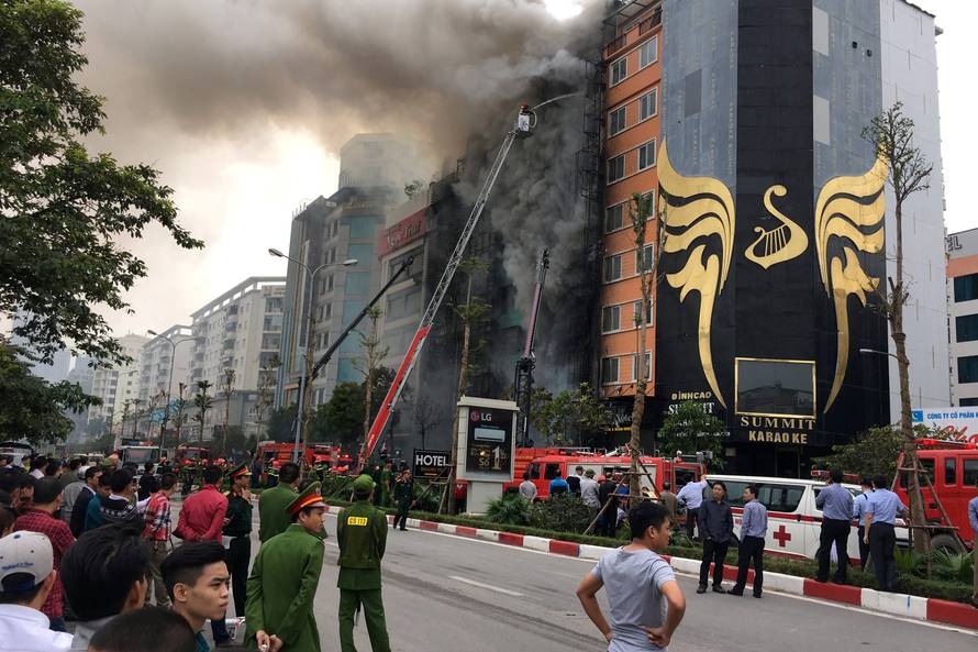 Firefighters work after a fire broke out at a karaoke lounge in Hanoi