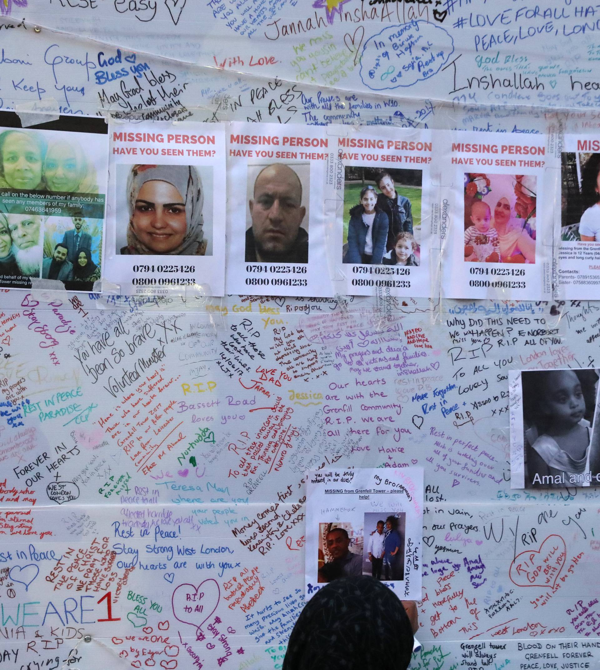 A man looks at a message wall near the scene of the fire which destroyed the Grenfell Tower block