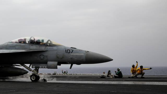FILE PHOTO: U.S. Navy catapult officers signal to an F/A-18 fighter jet pilot for a safe take off, aboard the USS Harry S. Truman aircraft carrier in the eastern Mediterranean Sea