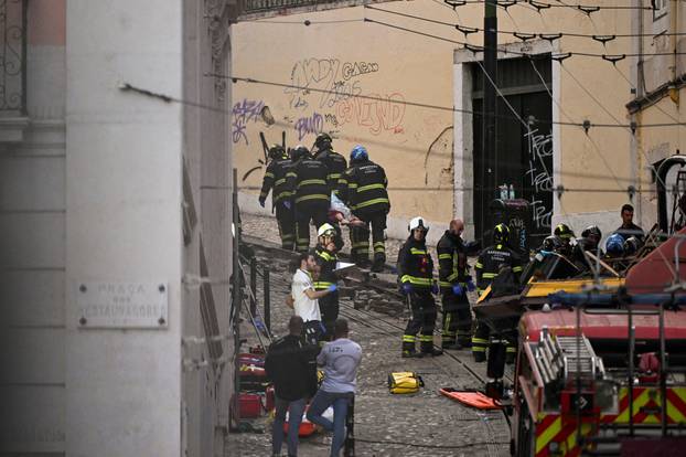 First responders work at the site of a funicular accident in Lisbon