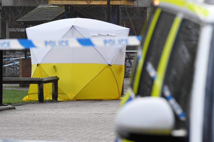 A police car is parked next to crime scene tape, as a tent covers a park bench on which former Russian inteligence officer Sergei Skripal, and a woman were found unconscious after they had been exposed to an unknown substance, in Salisbury