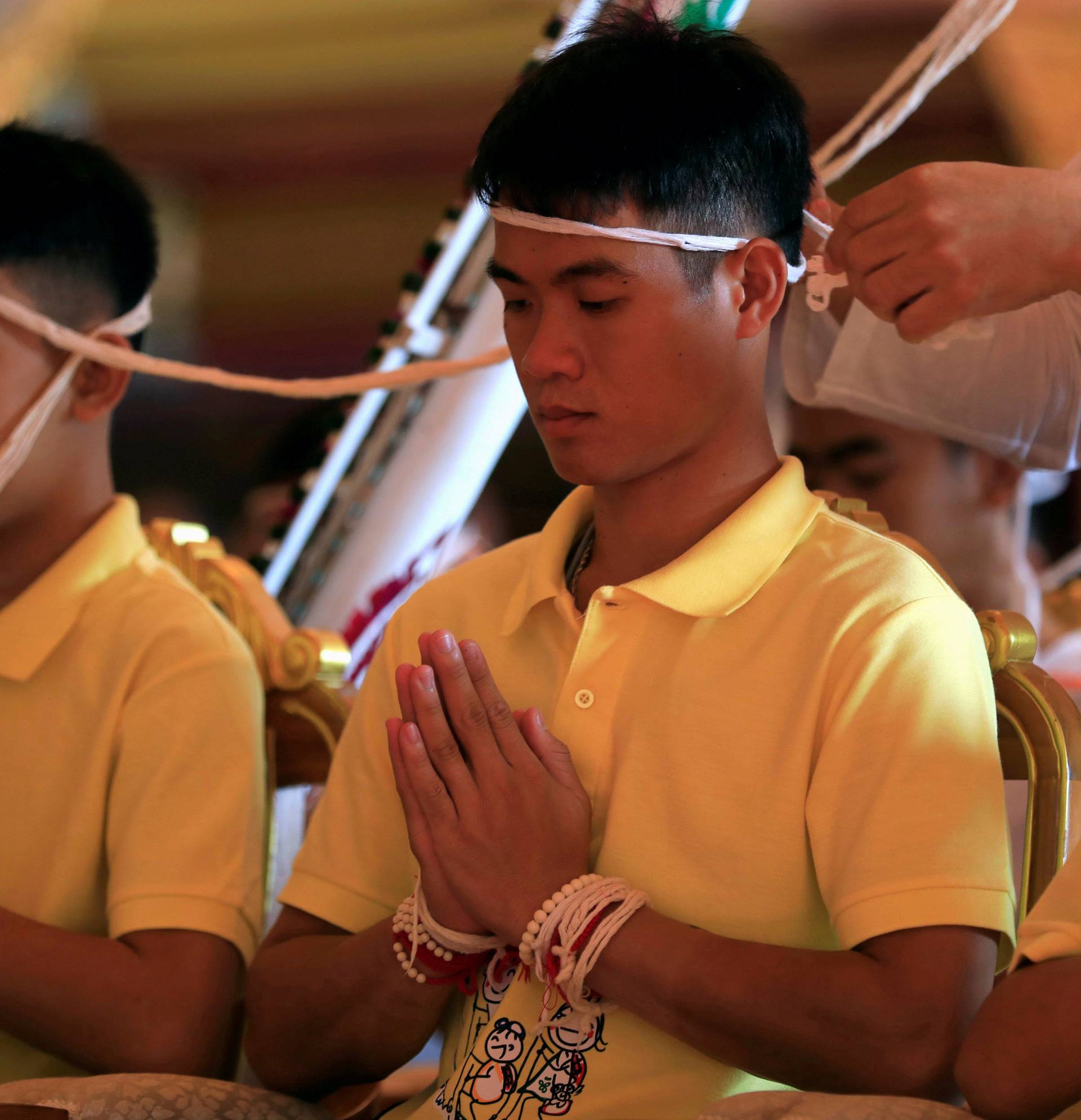 Members of a soccer team rescued from a cave attend a religious ceremony, in a temple at Mae Sai, in the northern province of Chiang Rai