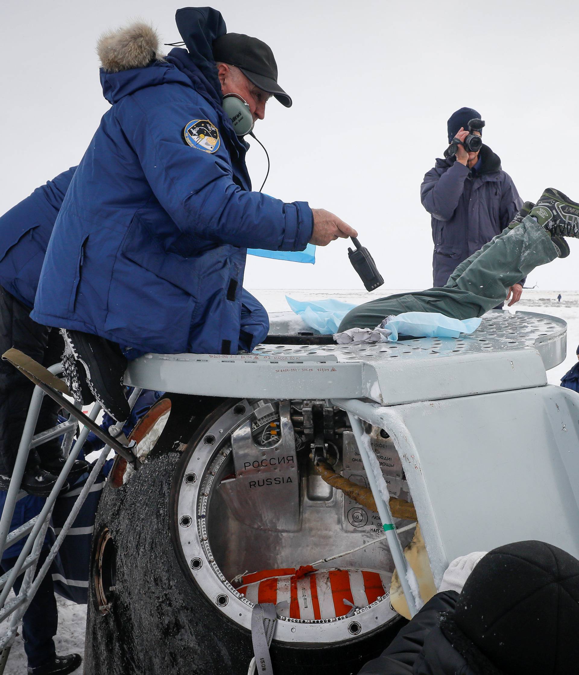 Search and rescue personnel surround the Soyuz MS-09 capsule carrying the International Space Station crew after landing near Zhezkazgan