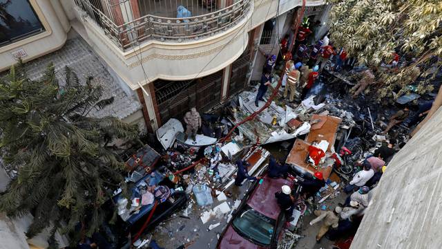 Rescue workers gather at the site of a passenger plane crash in a residential area near an airport in Karachi