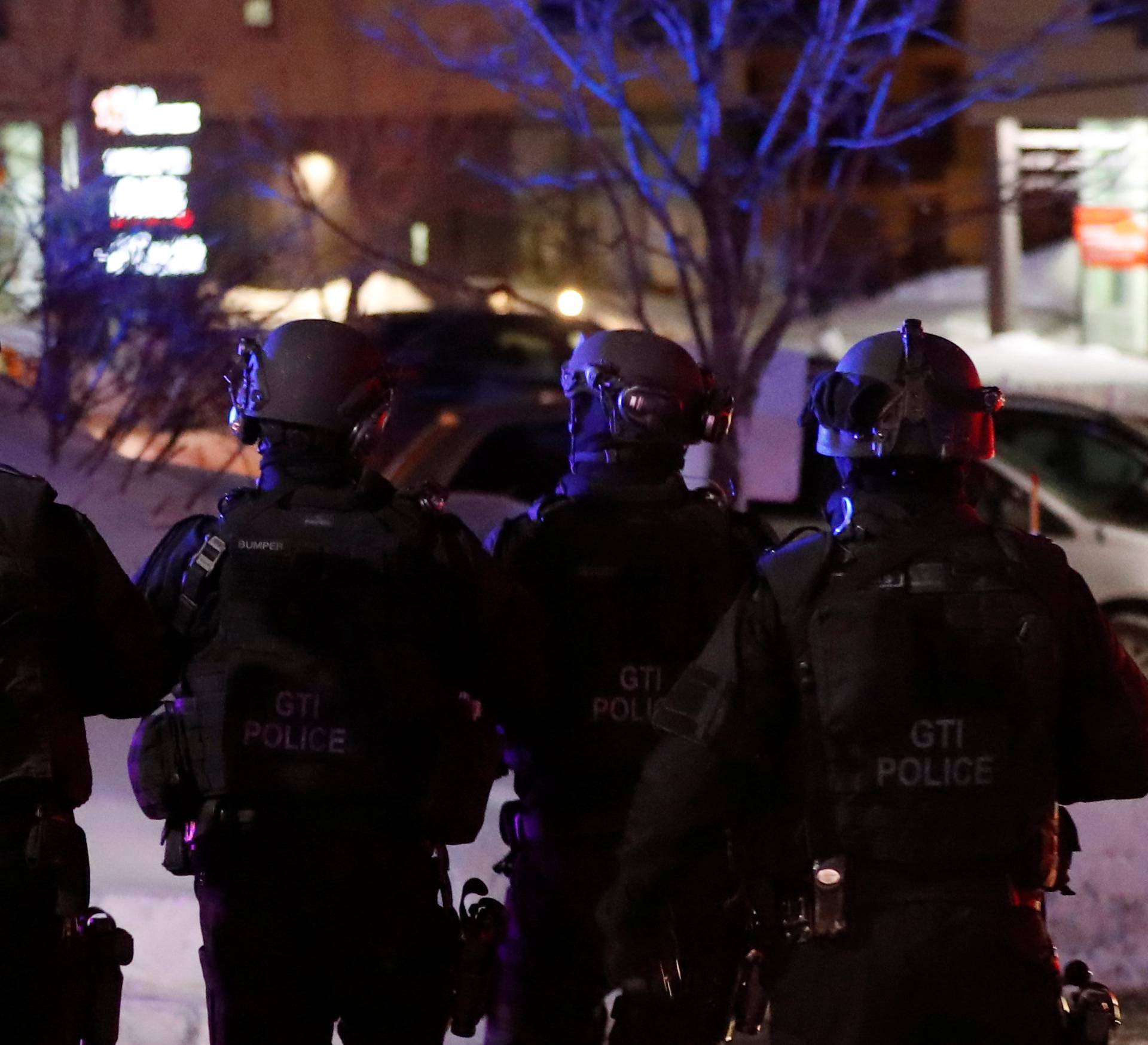 Swat team police officer walk aournd a mosque after a shooting in Quebec City