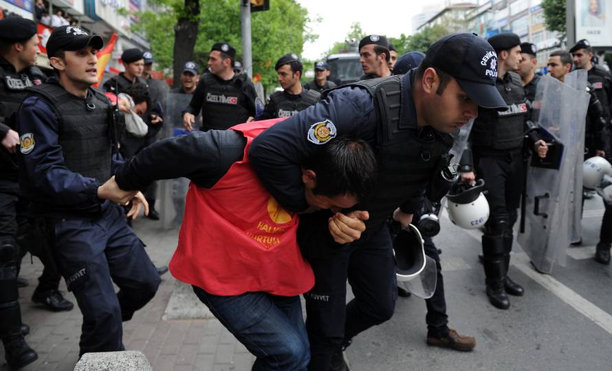 Turkish riot police detain a protester as he and others attempted to defy a ban and march on Taksim Square to celebrate May Day, in Besiktas neighbourhood of Istanbul