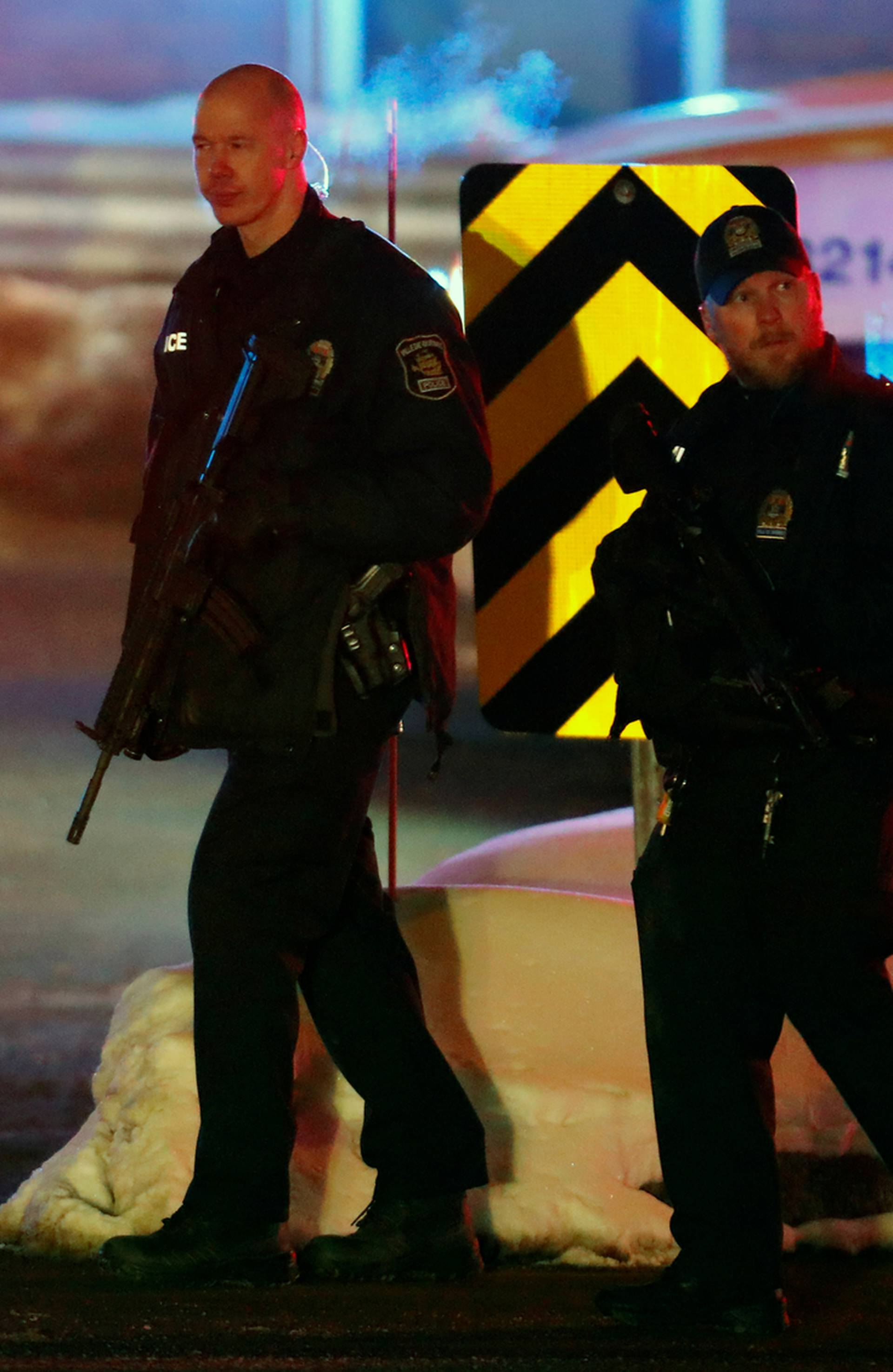 Police officers patrol the perimeter near a mosque after a shooting in Quebec City