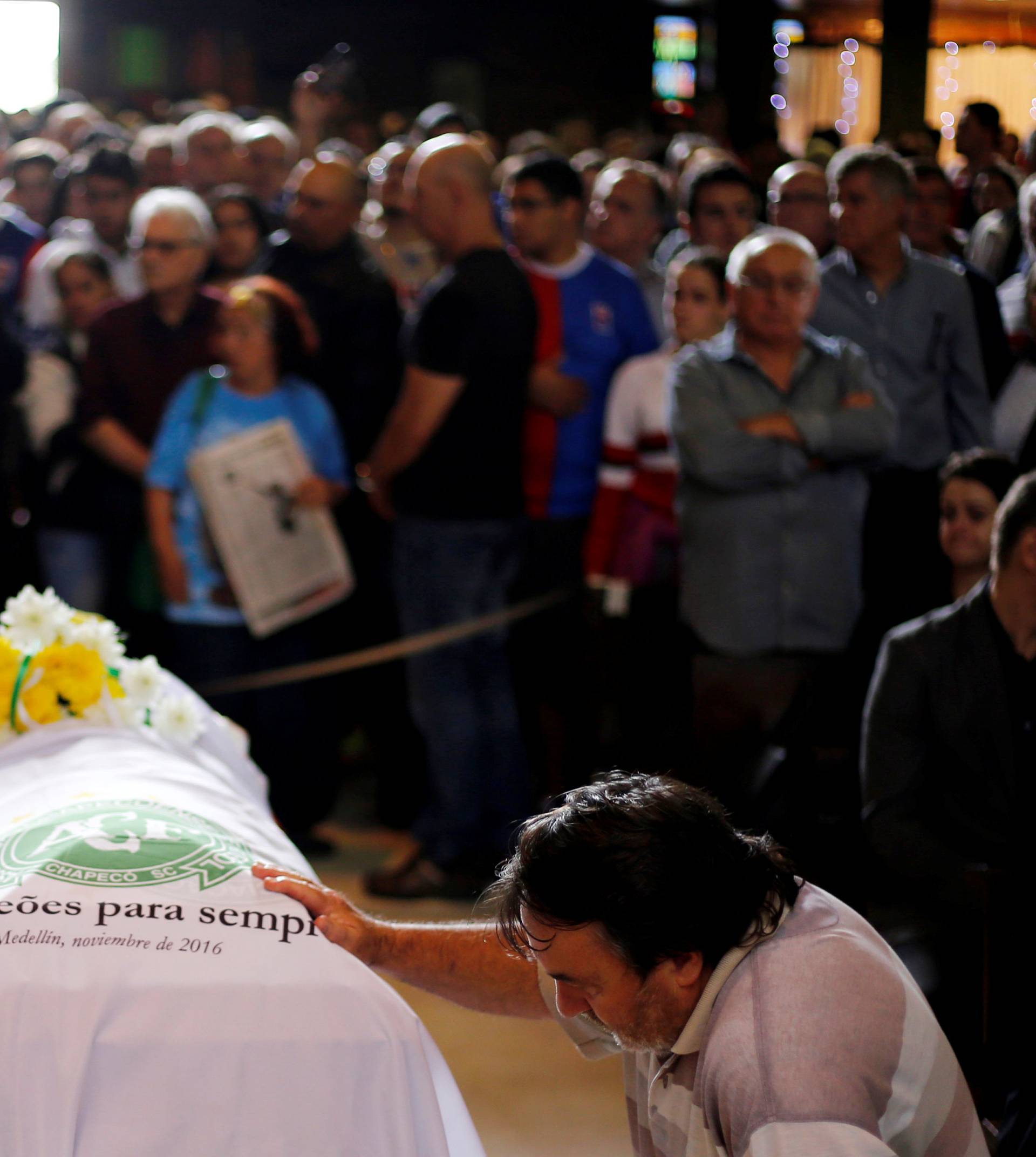 A soccer fan pays tribute next to the coffin of Chapecoense club head coach Caio Junior, who died in the plane crash in Colombia, during a ceremony in Curitiba