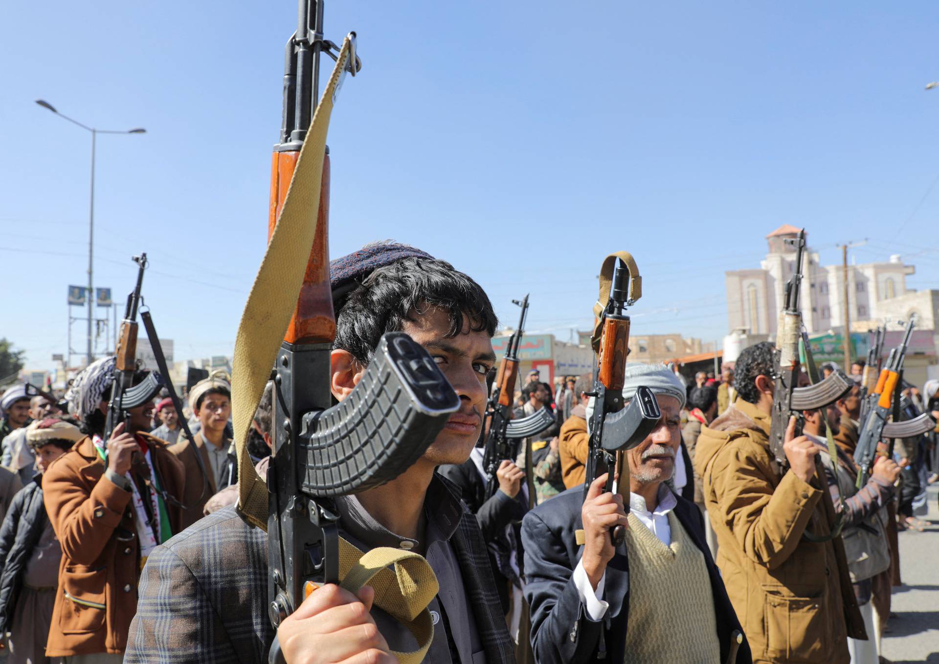 Newly recruited Houthi fighters hold up firearms during a ceremony at the end of his training in Sanaa