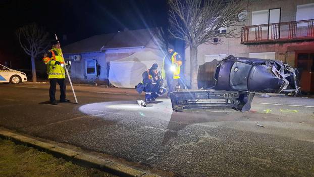 Police examine the scene of an accident near the Serbian border where car carrying migrants crashed into a house, in Morahalom