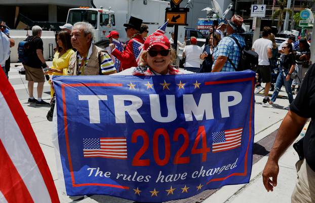 A supporter of former U.S. President Trump holds a banner near the Wilkie D. Ferguson Jr. United States Courthouse, in Miami
