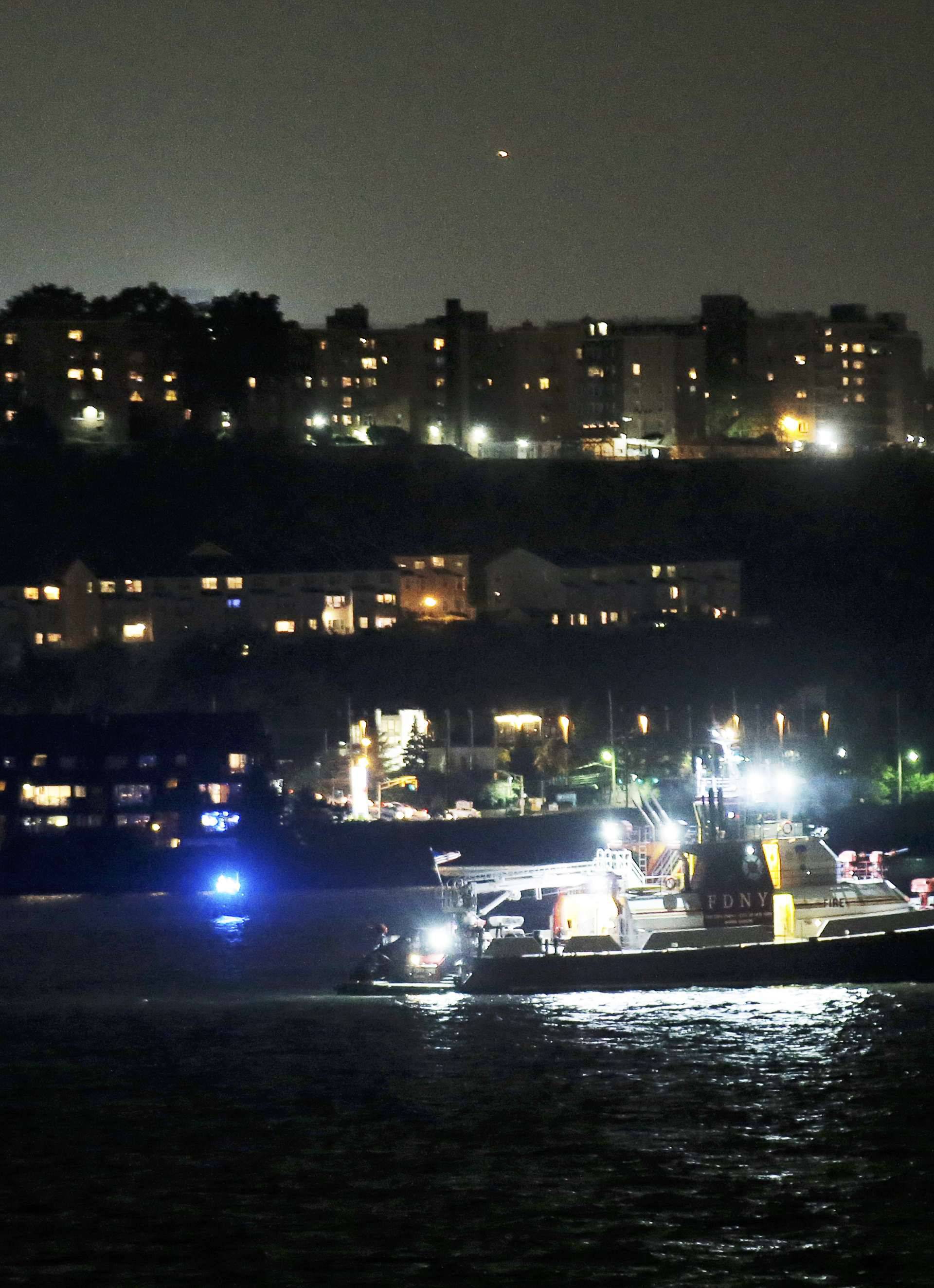 An FDNY fire department boat searches the Hudson River for the wreckage of a vintage P-47 Thunderbolt airplane that crashed in the river in New York City