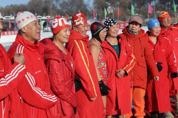Locals participate in winter swimming events during the annual ice and snow sculpture festival, in Harbin