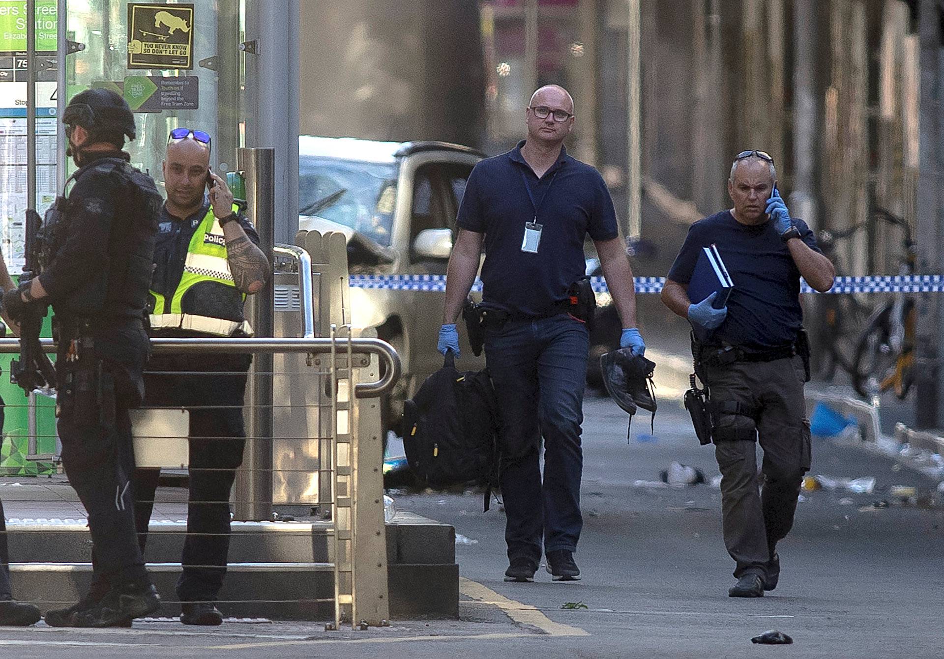 Australian police is seen near the place where they arrested the driver of a vehicle that had ploughed into pedestrians at a crowded intersection near the Flinders Street train station, in central Melbourne