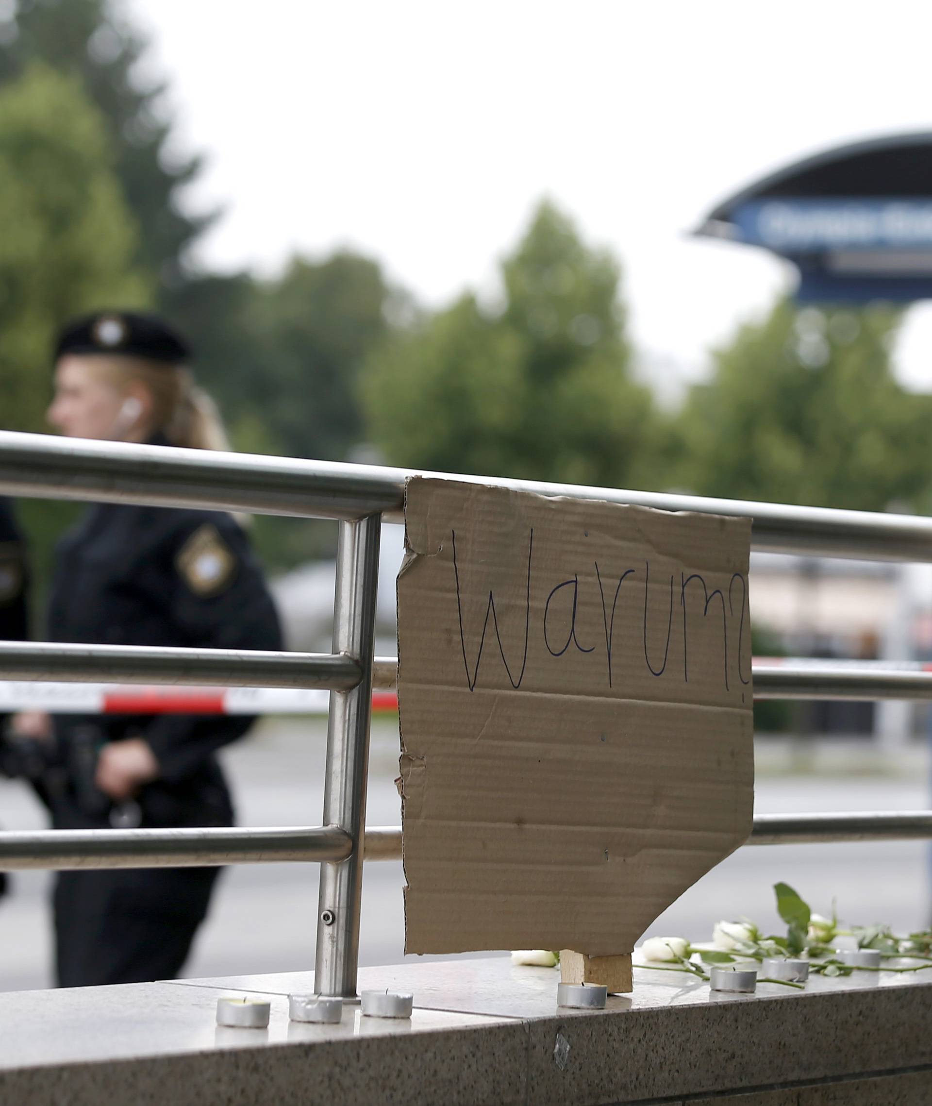 A sign reading 'Why'  and flowers are seen near Olympia shopping mall in Munich