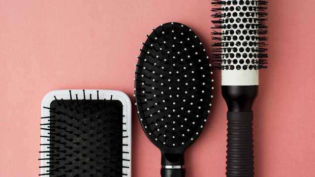 Used Hair brush tools on pink or coral background with copy space. Beauty fashion, hair care background.