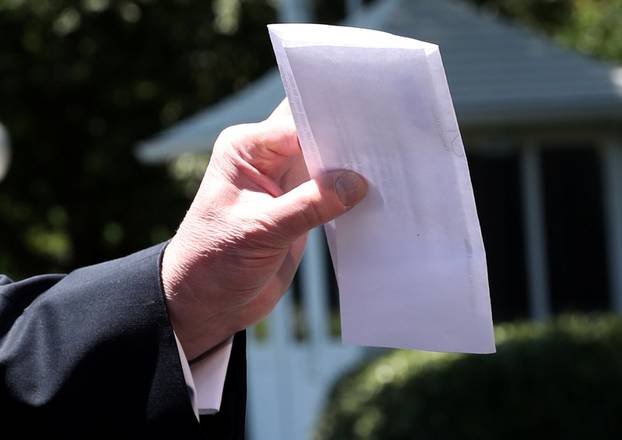 U.S. President Trump holds copy of regional asylum plan as he departs for travel to Iowa from the White House in Washington
